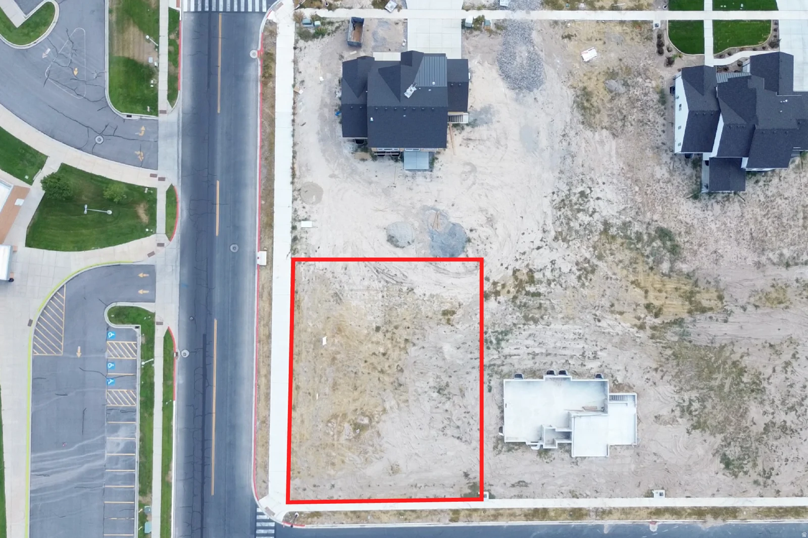 Vacant lot featuring a level terrain, bordered by a sidewalk, and proximate to established residential structures